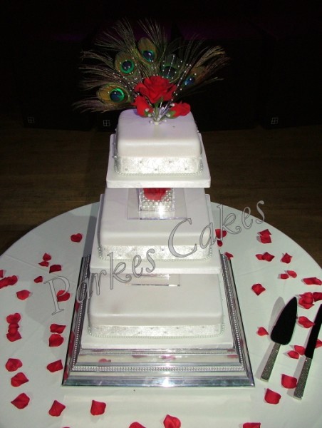 3 tier wedding cake with pearls, roses and peacock feathers